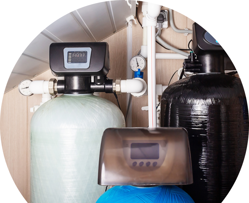 Wardlaw home water filtration system featuring resin tanks, digital control heads, pressure gauges, and connected piping in a utility room. Wardlaw home water filtration system featuring resin tanks, digital control heads, pressure gauges, and connected piping in a utility room.