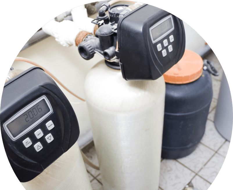 Wardlaw water softener installation showing dual resin tanks with digital control heads and a brine tank in a tiled utility area. Wardlaw water softener installation showing dual resin tanks with digital control heads and a brine tank in a tiled utility area.