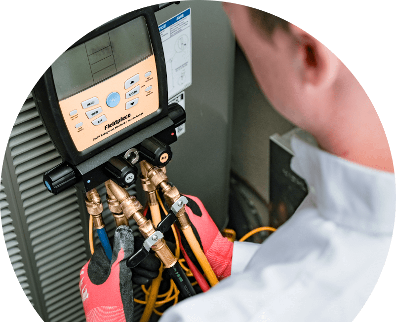 A Wardlaw home service crew member uses a digital manifold gauge to check refrigerant levels on an HVAC unit for service. A Wardlaw home service crew member uses a digital manifold gauge to check refrigerant levels on an HVAC unit for service.